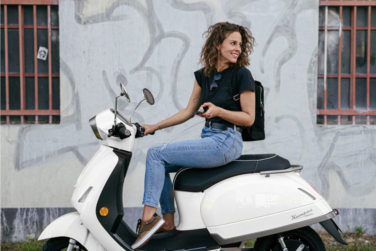 weißer E-Roller von Kumpan electric mit junger Frau